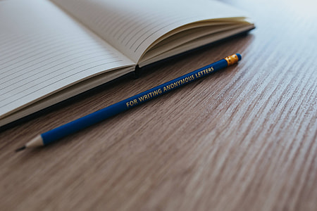 Notebooks with colourful pencils on a wooden desk thumbnail