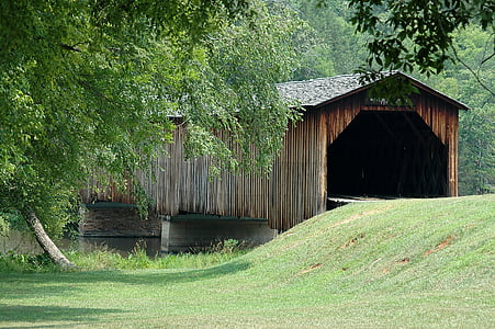 brown wooden tunnel over body of water during day thumbnail