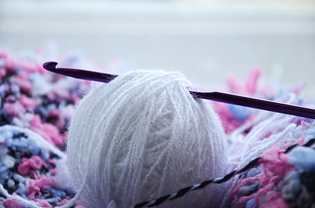 black crochet needle on white yarn ball thumbnail