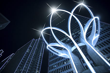 high angle photo of flower-shaped gray lighted infrastructure near high-rise building during daytime thumbnail