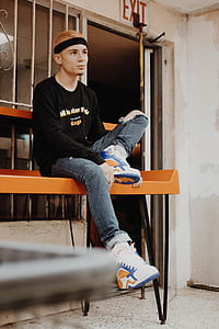 man sitting on orange wooden table thumbnail