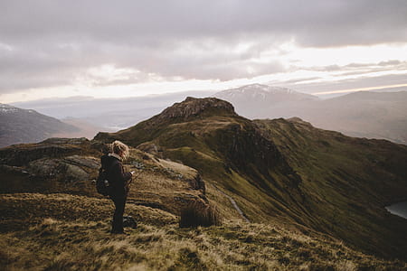 aerial photography of woman standing on mountain thumbnail
