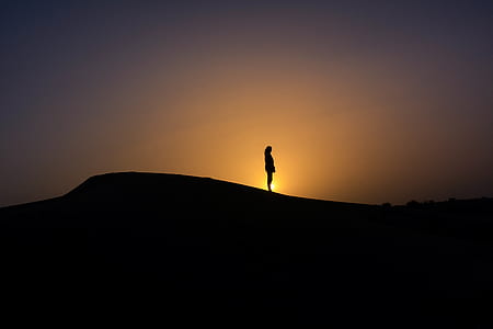 silhouette of person standing on mound thumbnail