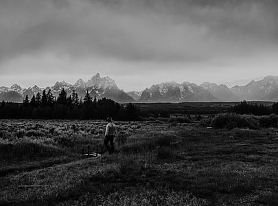 grayscale photography of person standing on grass thumbnail