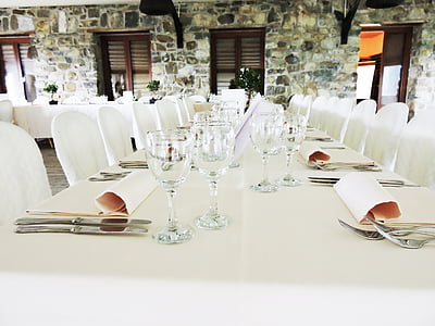 clear drinking glasses between cutlery on table thumbnail