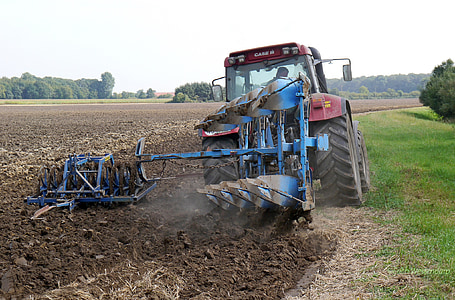 person riding on blue farm tractor with cultivator thumbnail
