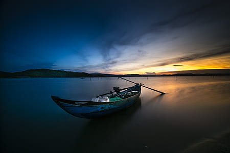 photo of canoe on body of water during golden hour thumbnail