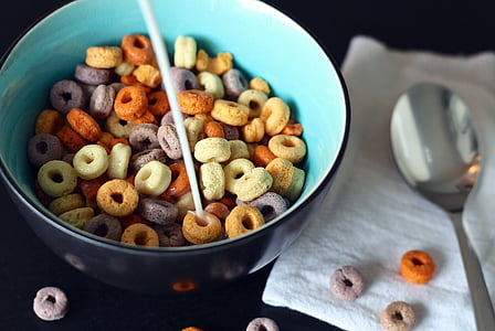 milk poured onto cereals in bowl next to spoon thumbnail