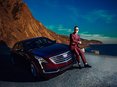 man sitting on front of red car thumbnail