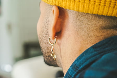 man wearing gold-colored dangling earring thumbnail