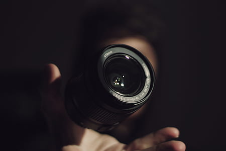 person showing black DSLR camera zoom lens thumbnail