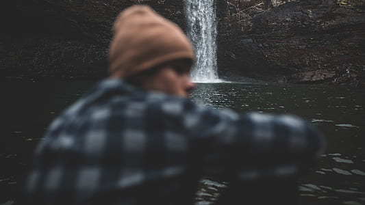 waterfalls behind a man wearing black and white dress shirt thumbnail
