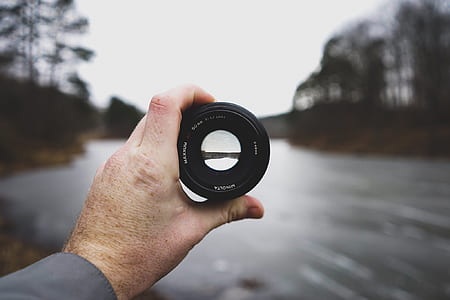 photo of person holding black camera lens thumbnail