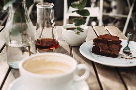 chocolate cake on ceramic plate beside coffee in cup thumbnail