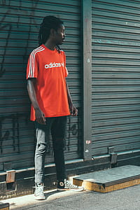 man weaing adidas shirt standing near the roller shutter thumbnail
