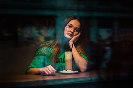 woman in green shirt lying on table in front of drink thumbnail