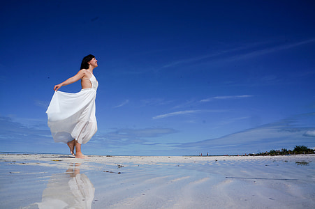 woman in white sleeveless dress on shore under blue sunny sky thumbnail
