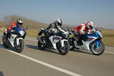 three motorcycle racers on road thumbnail