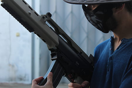 man holding rifle with mask on face thumbnail