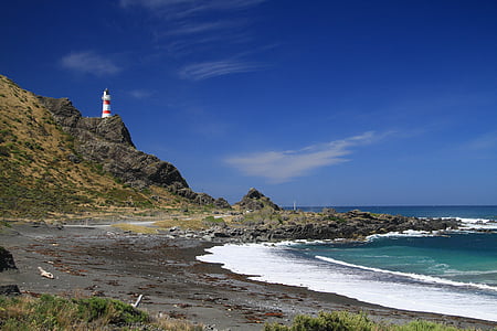 lighthouse on top of hill near seashore thumbnail