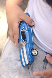 boy holding blue and white Chevrolet Camaro SS coupe die-cast model thumbnail