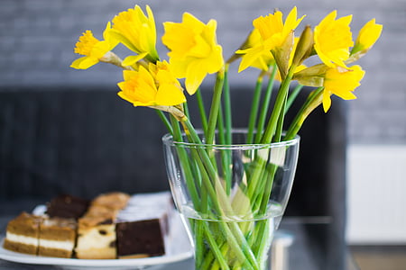 yellow flowers in clear vase thumbnail