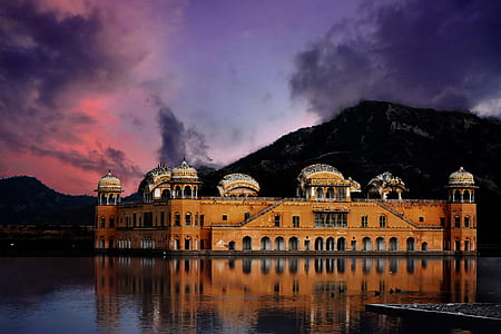 photography of brown concrete building near body of water thumbnail