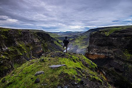 person standing on cliff under gray sky at daytime thumbnail