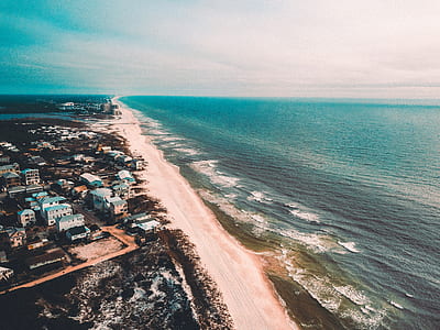 aerial photography of houses near coastline at daytime thumbnail
