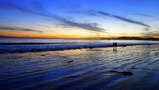 silhouette photo of two persons on body of water thumbnail