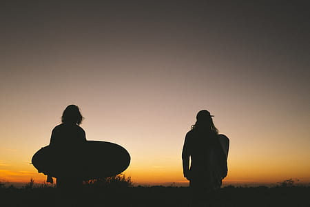 silhouette of two person standing under golden sky thumbnail