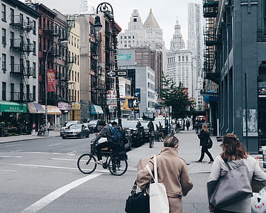 woman in brown coat walking on concrete road during daytime thumbnail