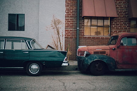 two vehicles parked on driveway near wall thumbnail