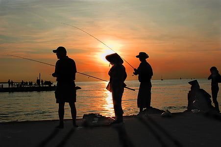 silhouette of people beside seashore thumbnail