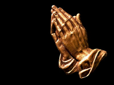 closeup photo of brass-colored praying hands figurine thumbnail
