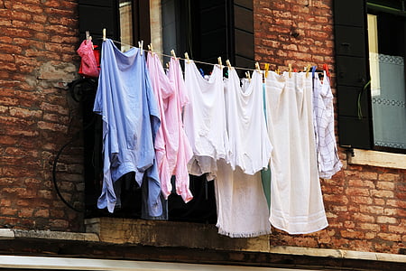 women's clothing lot hanging beside window during daytime thumbnail