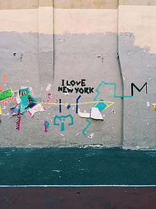 green concrete pathway near gray concrete wall with i love New York-printed and paintings at daytime thumbnail