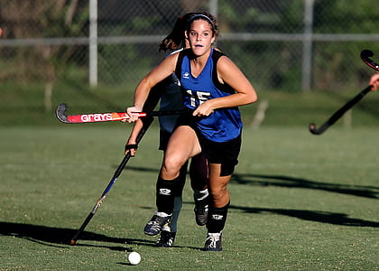 Woman Wearing Blue and Black Jersey Holding Field Hockey thumbnail