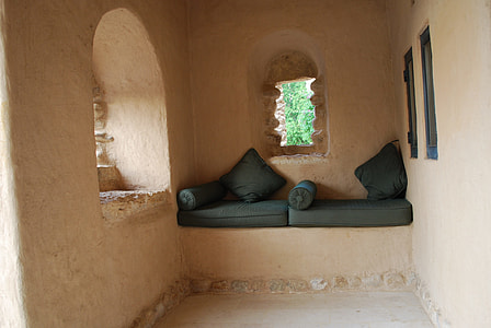 two green padded bed beside concrete window thumbnail