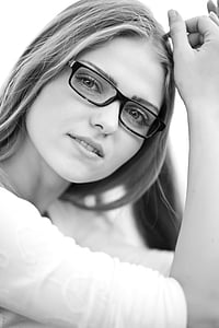grayscale photo of woman wearing elbow-sleeved shirt and eyeglasses thumbnail