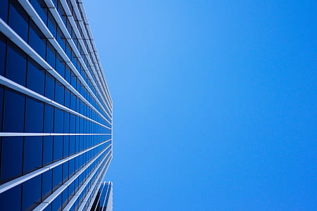 low-angle photo of curtain wall high-rise building under blue clear sky at daytime thumbnail