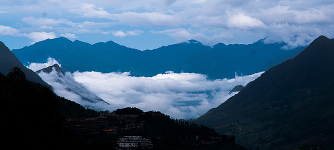 silhouette photo of fogs surrounded with mountains thumbnail