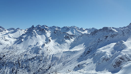 snow-covered mountains under blue sky thumbnail