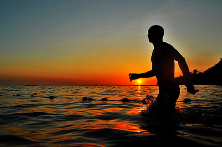 silhouette photography of man in water thumbnail