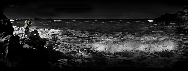 woman sitting on rock at the shore thumbnail