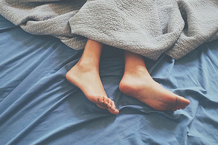 Feet of person sleeping in house home bed thumbnail