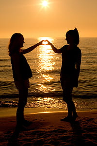 women standing near shore thumbnail