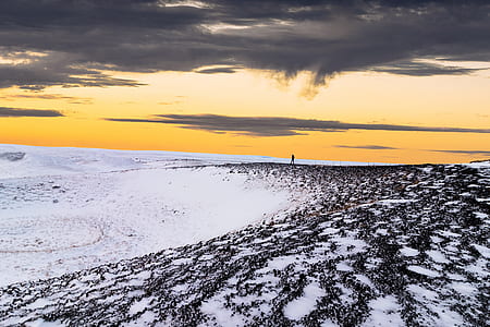 snow covered ground under brown and black sky thumbnail