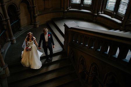 couple holding hands walking on stair inside building thumbnail