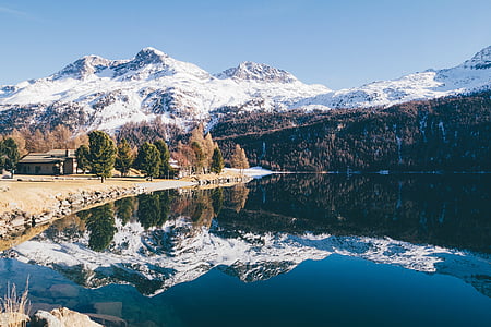 body of water near mountain peaks thumbnail